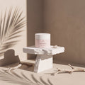 MINT DETOX de Nitiel sobre un pedestal de piedra, con sombras de palmera