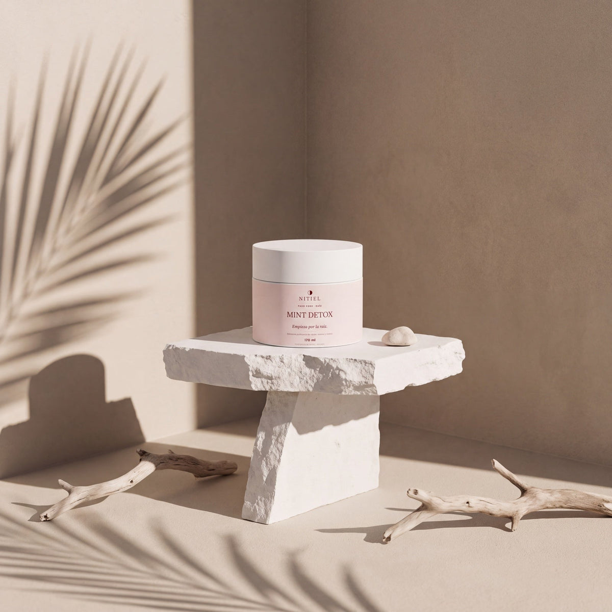MINT DETOX de Nitiel sobre un pedestal de piedra, con sombras de palmera