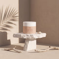 MASK REPAIR de Nitiel sobre un pedestal de piedra, con sombras de palmera