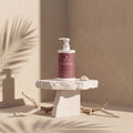 VOLUMINIX de Nitiel sobre un pedestal de piedra, con sombras de palmera